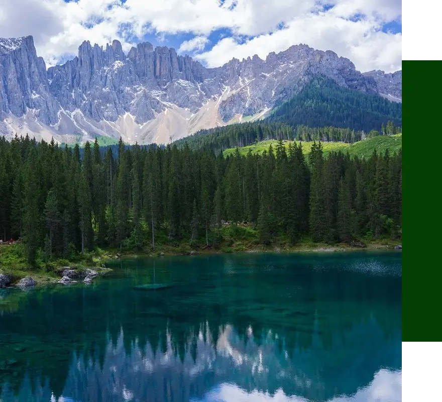 A painting of the mountains and trees in front of a lake.