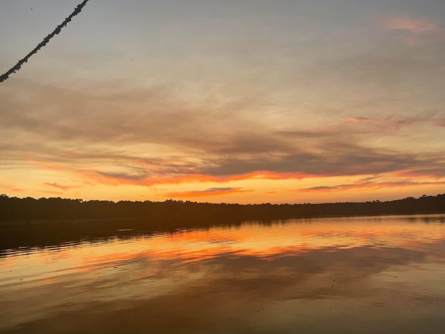 A sunset over the water with a boat in it.